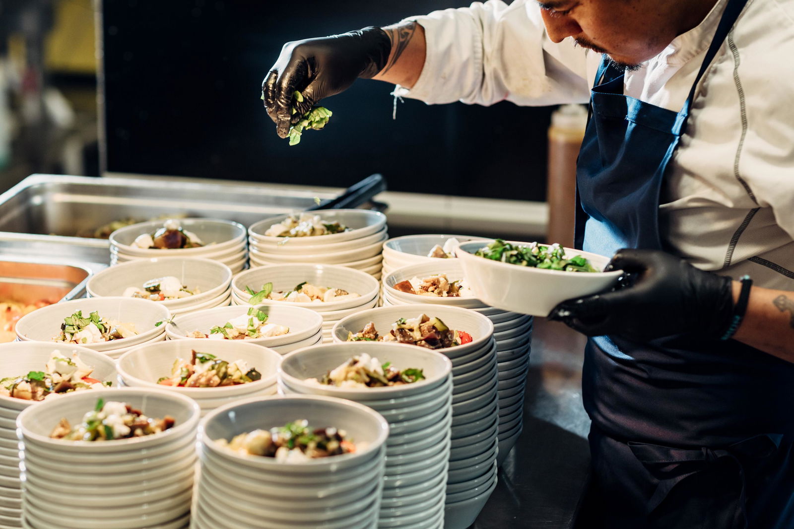 Kokk legger opp salat i skåler