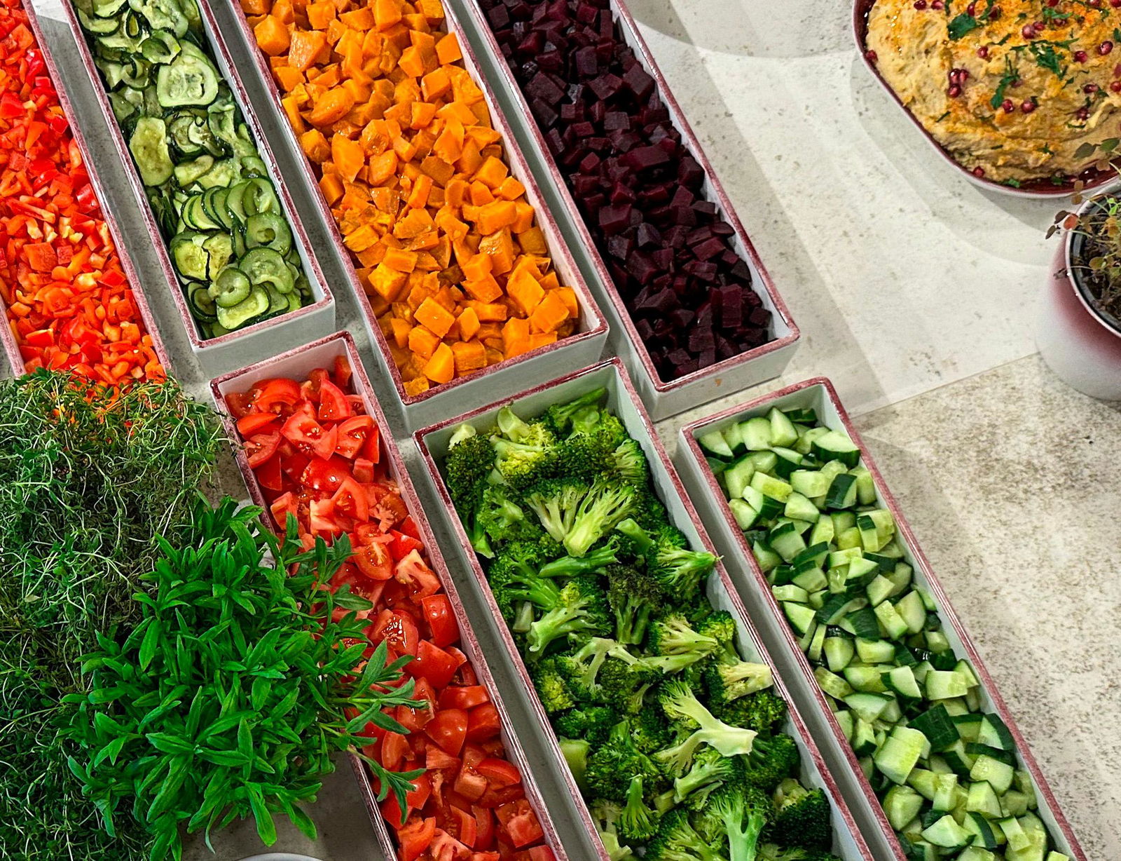 Hånd forsyner seg av varmrett på tallerken fra buffet i kantine