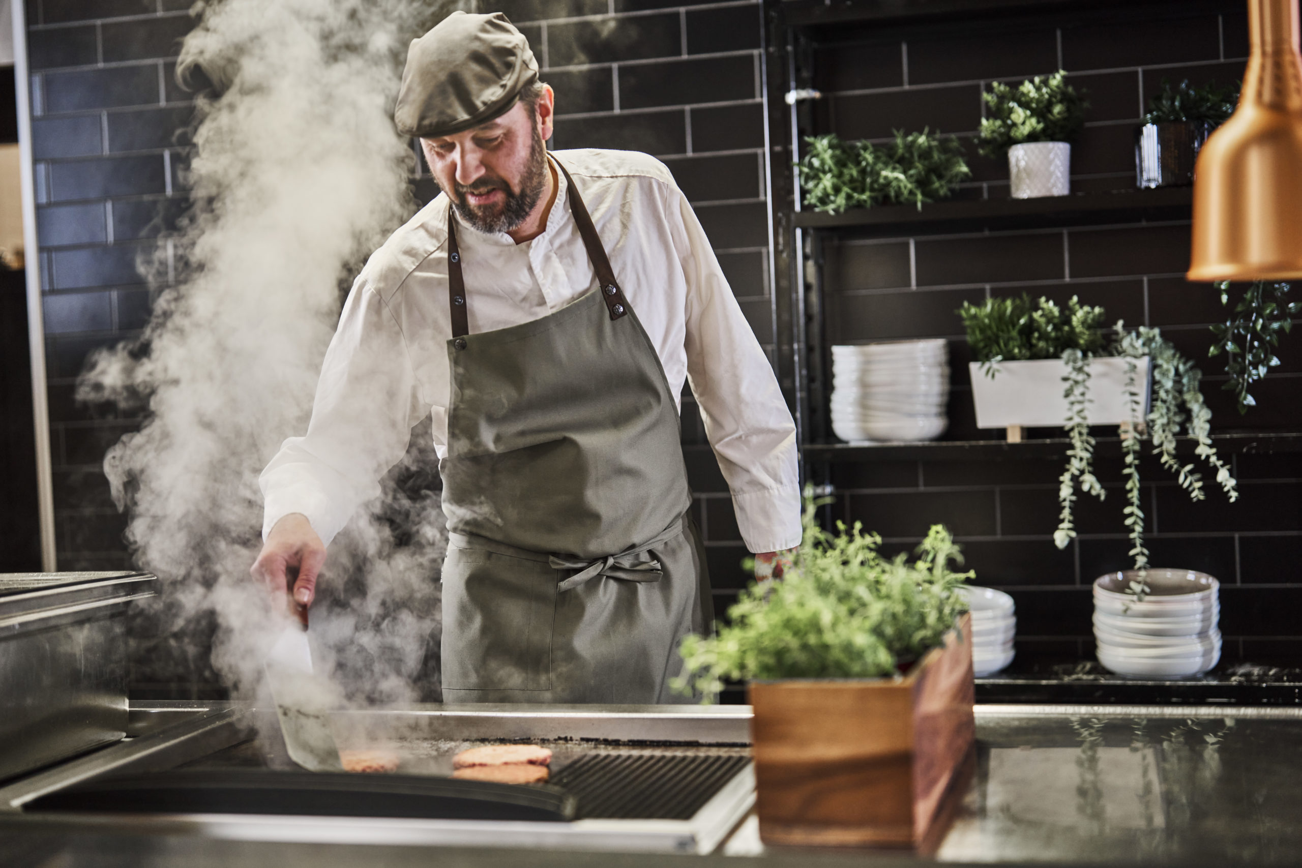 Kokk steker burgere i Smoky Flavours matbod